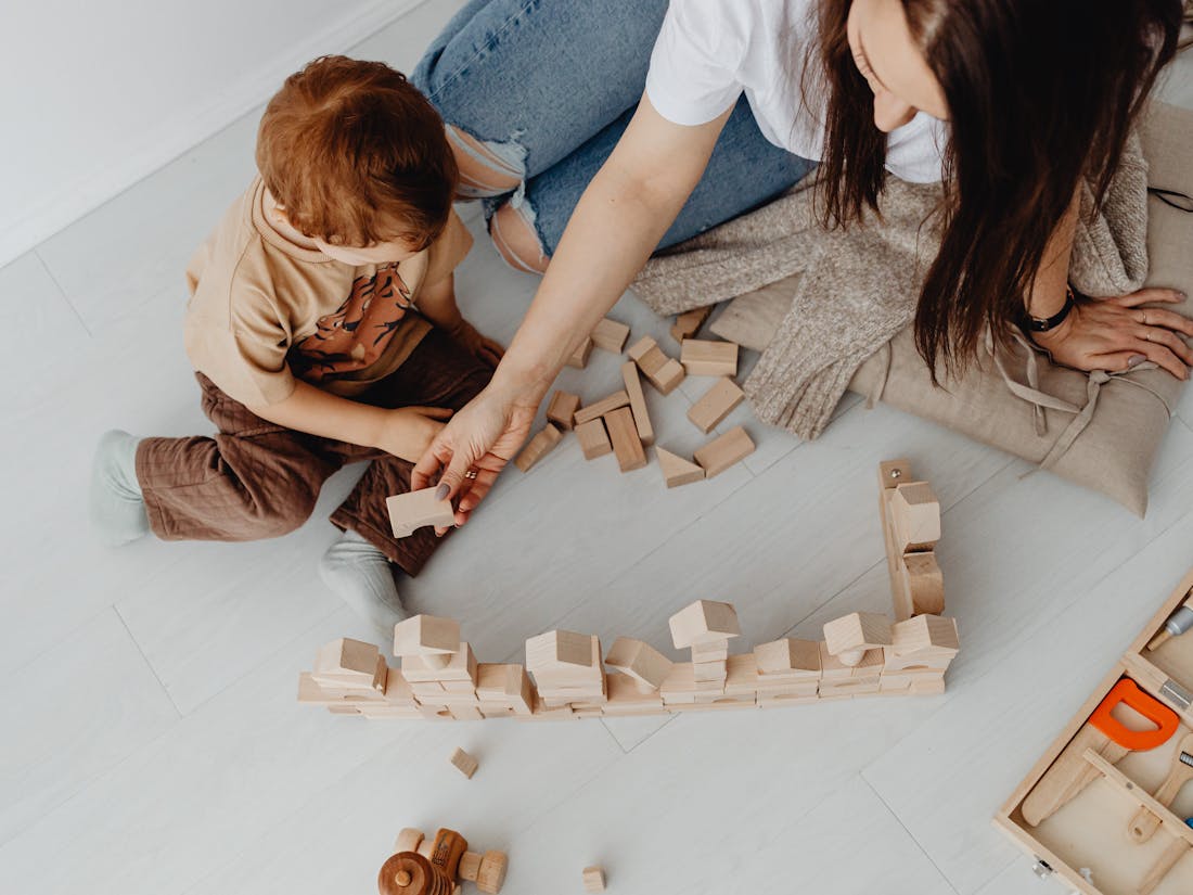 In-home ABA therapy session — RBT and child learning through play on the living-room floor